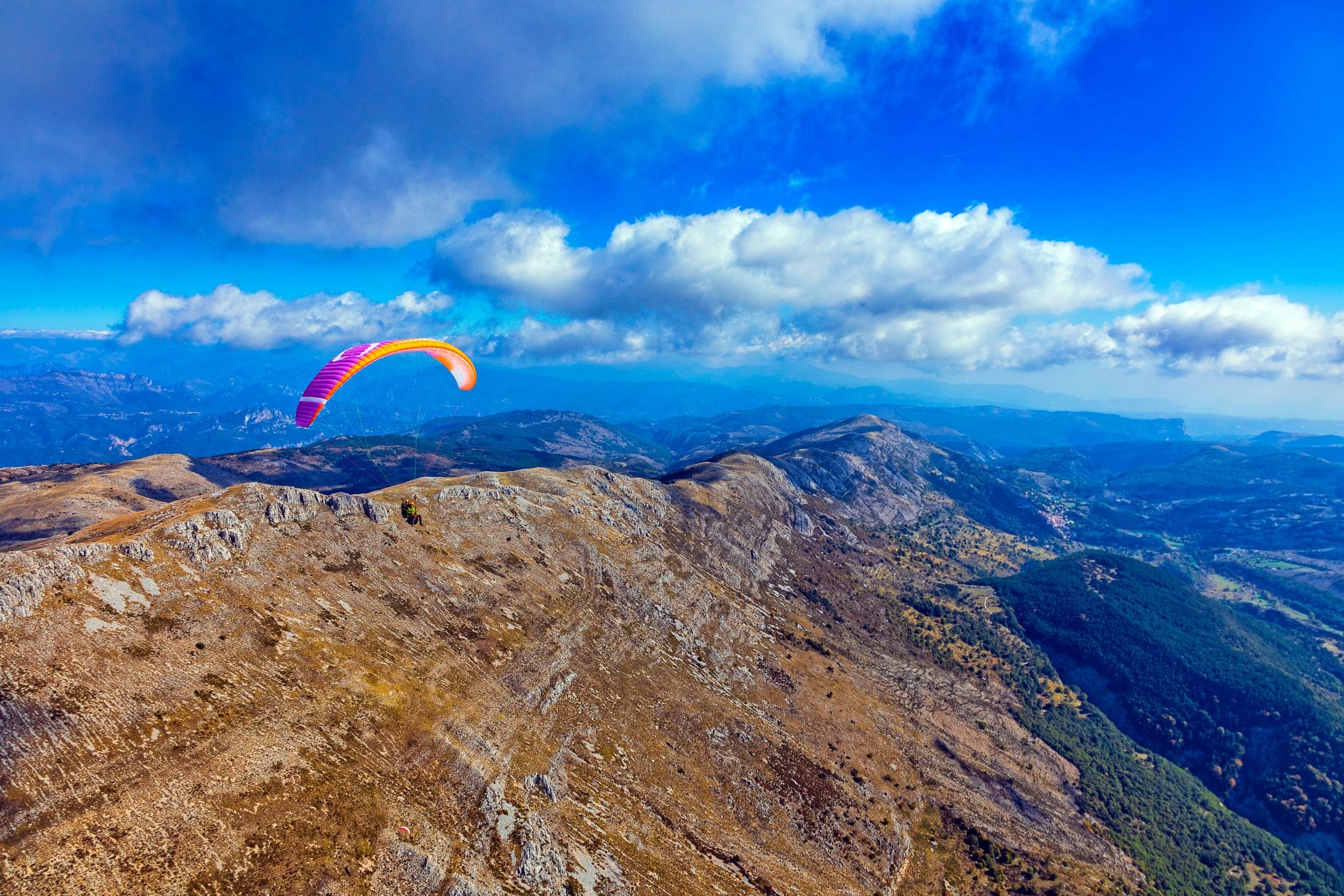 Pilote de parapente observant les nuages et le vent avant de décoller en montagne