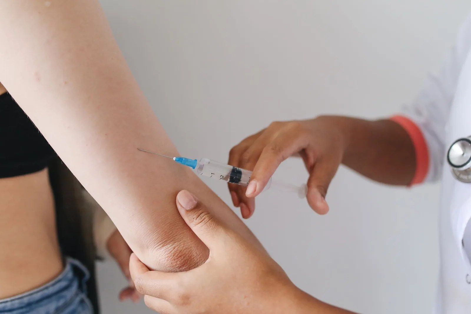Carnet de vaccination et passeport posés sur une valise avant un départ pour la Thaïlande
